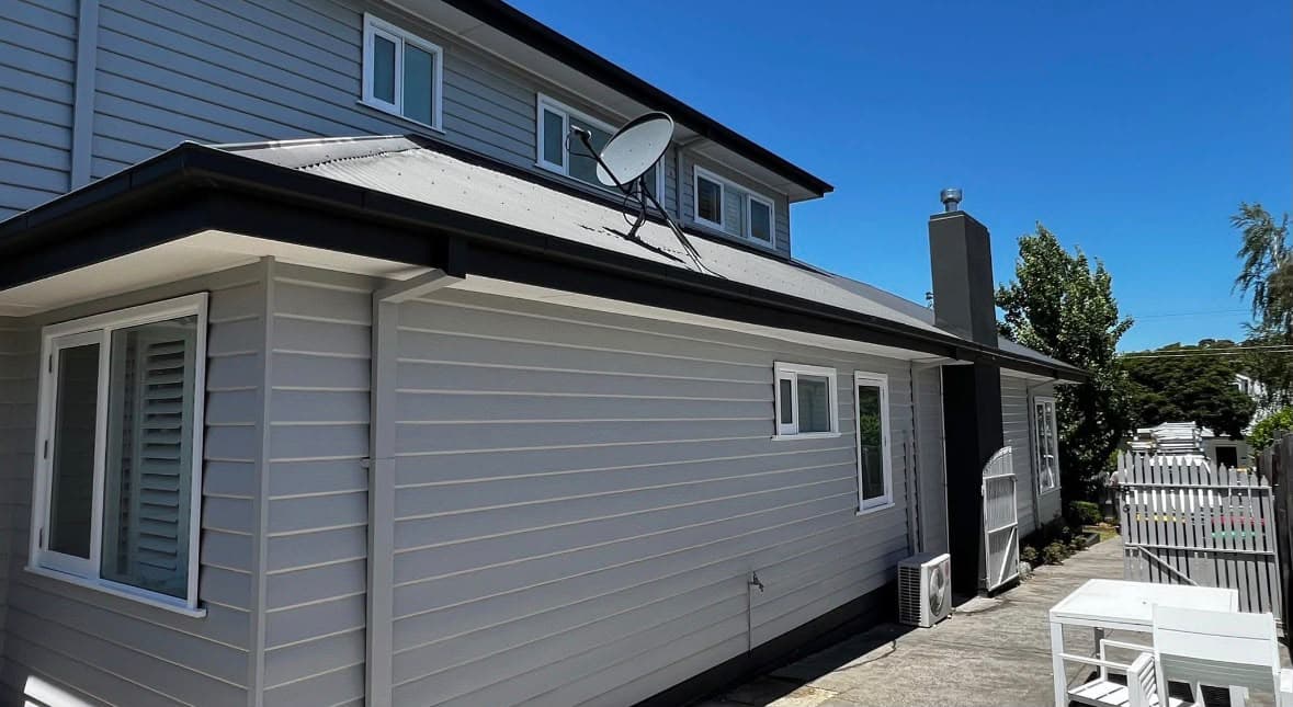 Grey two-storey weatherboard exterior with bright white windows