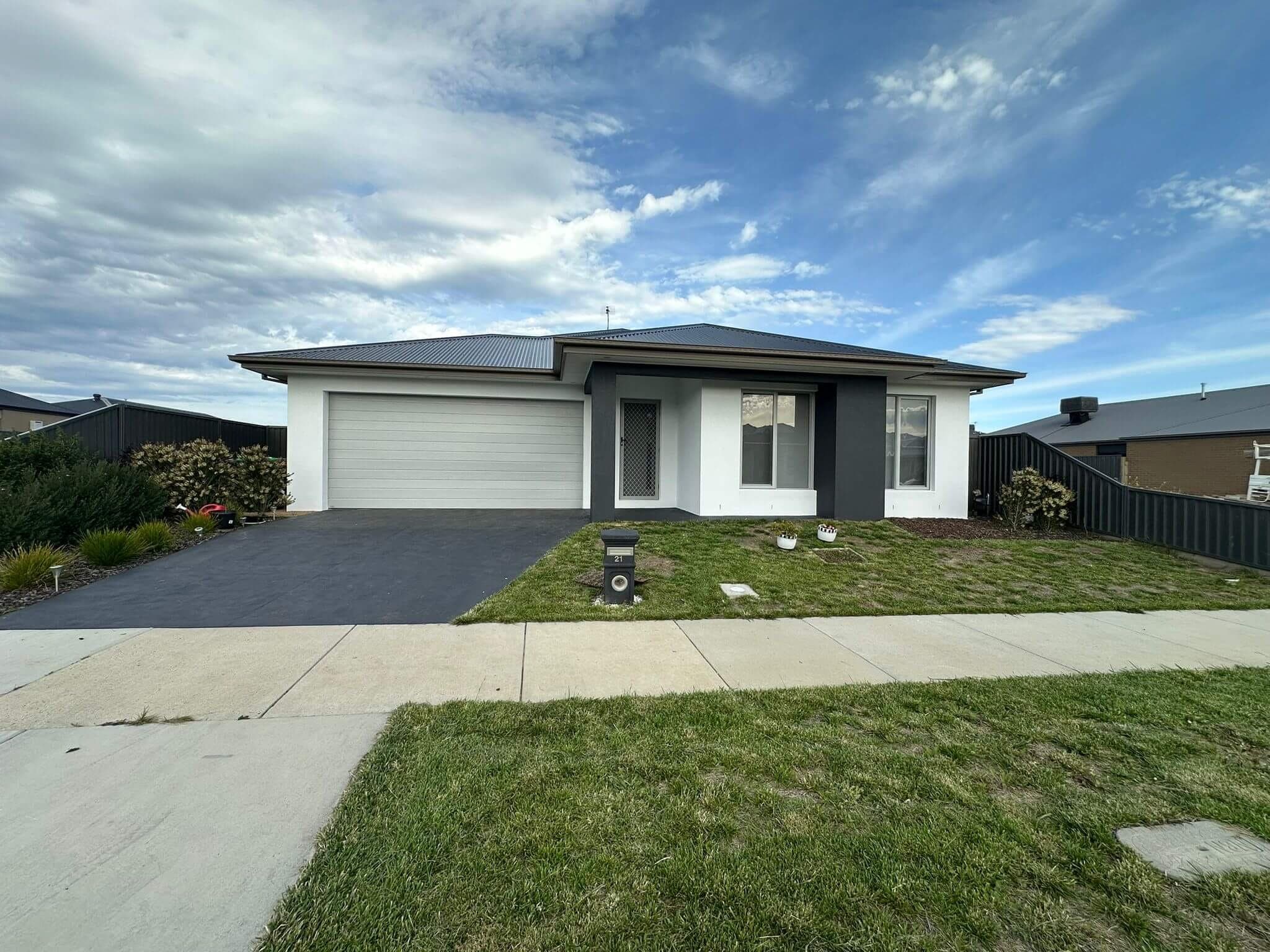 Completed white and charcoal exterior repaint on a modern home