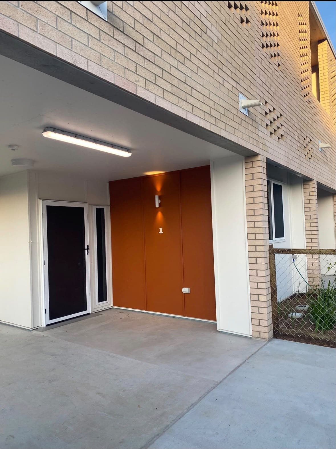 Covered entry finished in warm orange with crisp white panels