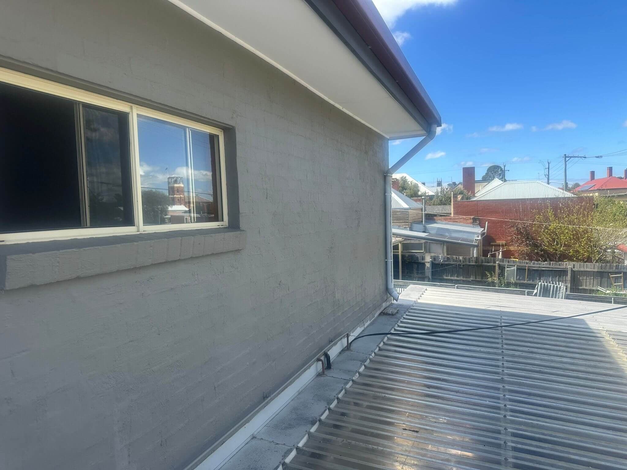 Freshly coated masonry exterior with Melbourne rooftops beyond