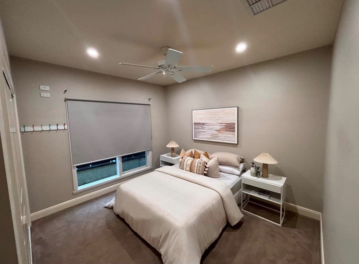 Finished bedroom with warm neutral walls and crisp white trim