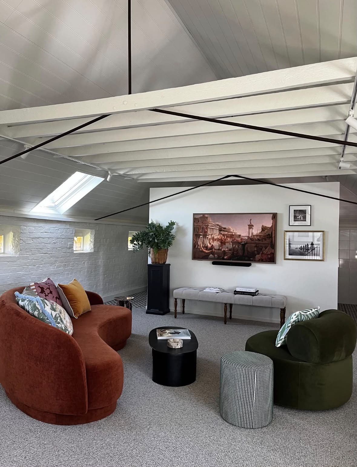 White loft living area with painted beams and brickwork