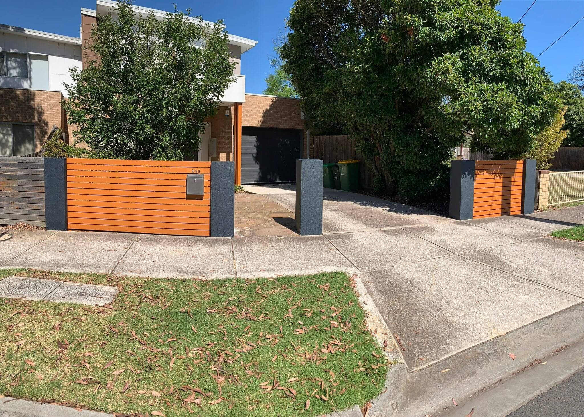 Wide view of a restored timber fence and coated entry pillars