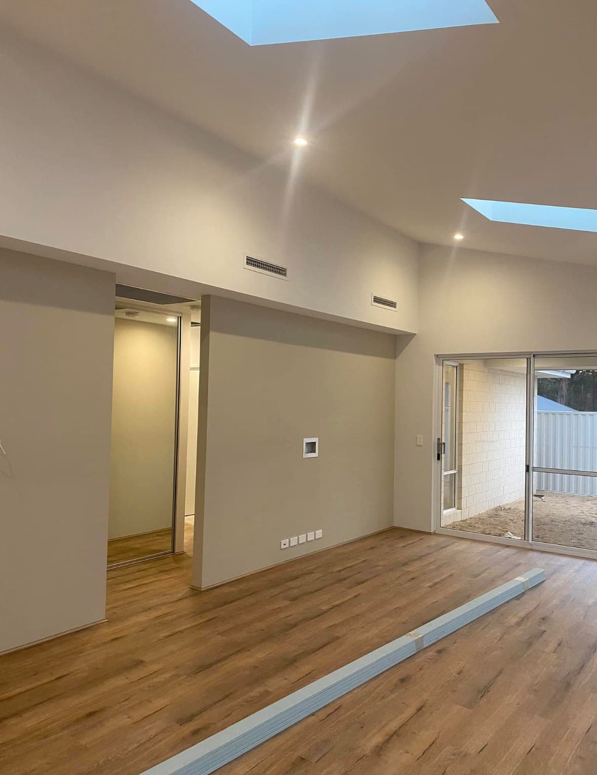 Interior painting project in progress beneath large skylights